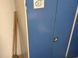 a blue cabinet with a sign on it next to a pile of boxes