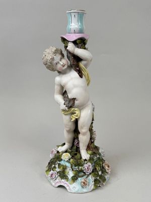 une figurine représentant un garçon tenant un oiseau sur la tête