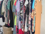 a lot of clothes hanging on a rack in a room