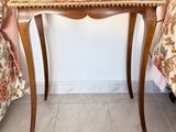 a small wooden table with a floral cloth on top of it