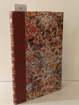 un livre à la couverture rouge posé sur une table blanche