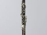 a close up of a clarinet on a clear stand on a white background