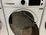 une machine à laver et un sèche-linge posés l'un à côté de l'autre sur le sol