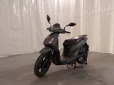 un scooter garé dans une pièce avec un rideau blanc