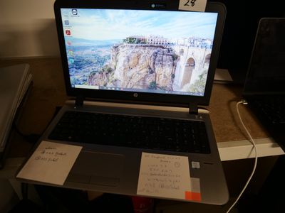 a laptop computer sitting on a desk with a note on it