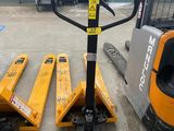 un chariot élévateur transportant deux palettes dans un entrepôt