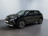 un SUV noir garé dans une pièce aux murs blancs