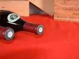 two bottles of wine sitting on a red table
