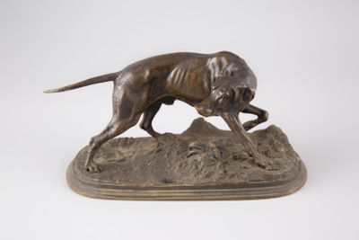 statue en bronze représentant un chien courant sur un rocher, sur fond blanc