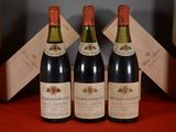 three bottles of wine are sitting on a red table cloth