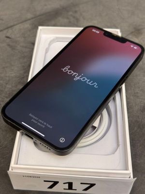 Un iPhone est posé sur une boîte, sur une table.