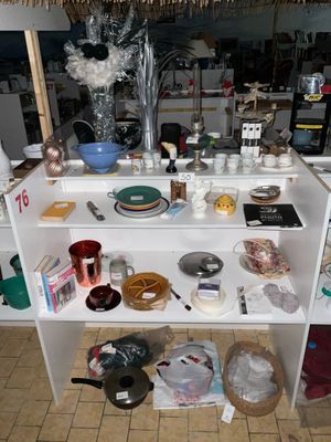 une étagère blanche sur laquelle sont posés divers objets, dans une cuisine
