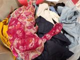 a pile of clothes in a suitcase on the floor