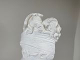 a white statue of a woman wrapped in a blanket