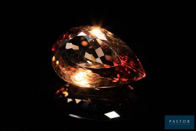 un diamant orange sur une surface noire