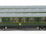 two green trains sitting side by side on a white surface
