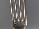 a close up of a fork on a plate on a table
