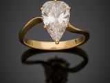 une bague sertie d'un diamant en forme de poire sur un fond noir