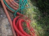 un tas de tuyaux posé par terre à côté d'un bâtiment