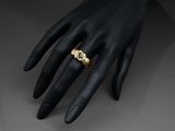 a close up of a person ' s hand with a gold ring on it