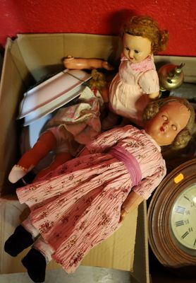 une poupée dans une boîte, avec une horloge posée sur la table