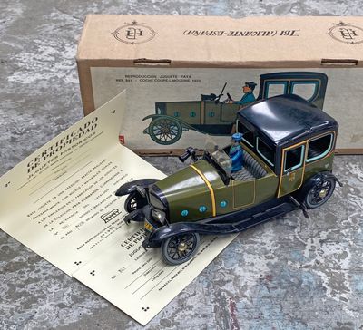 une petite voiture miniature posée sur une table, à côté d'une boîte