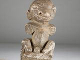 an image of a statue of a person sitting on a rock
