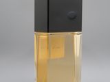 a bottle of perfume on a gray surface with a gray background