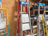 Plusieurs échelles sont alignées contre le mur d'un immeuble