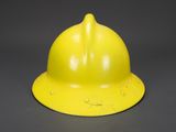 an image of a yellow fireman ' s helmet on a gray background