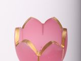 a pink glass vase with a gold decoration on it