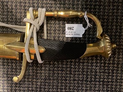 a gold sword with a black handle on a carpet