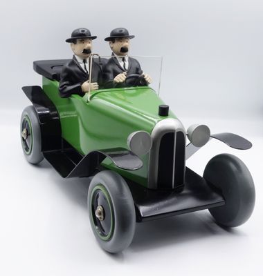 deux figurines représentant un homme et une femme dans une voiture verte