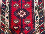 a red and blue rug with a diamond design on it