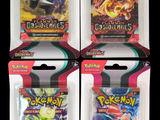 quatre paquets de cartes à collectionner Pokémon dans leur emballage en plastique, sur fond noir