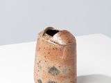 l'image d'un vase brun posé sur une table blanche