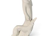 une figurine blanche représentant un homme assis sur un chien