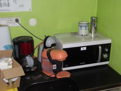 un micro-ondes posé sur un plan de travail, à côté d'une cafetière