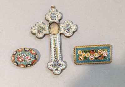 une croix, une broche et une broche posées sur une table