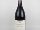une bouteille de vin rouge posée sur une table blanche