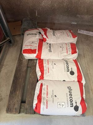 trois sacs de ciment posés sur une palette