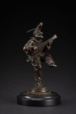 a bronze figurine of a man playing a guitar