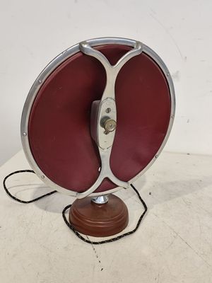 une photo d'une lampe de table rouge et argentée posée sur une surface blanche
