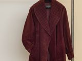 un manteau en velours bordeaux suspendu à un portant dans une pièce