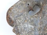 an old stone object with a hole in it on a white surface