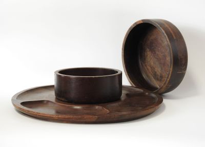 a wooden cup and saucer sitting on a plate