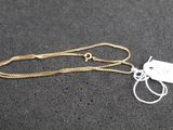a close up of a gold chain with a tag attached to it
