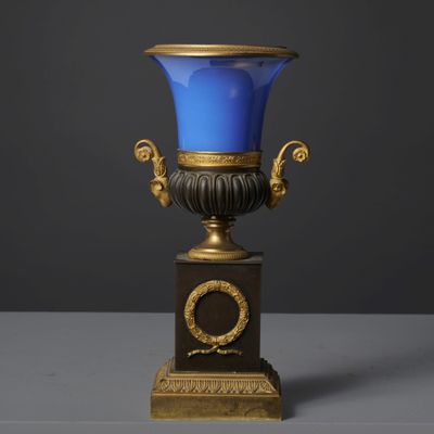 a blue vase sitting on top of a wooden base