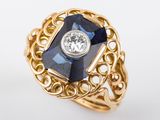 une photo d'une bague en or sertie d'une pierre bleue et d'un diamant