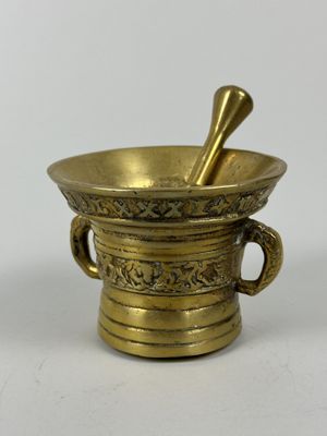 Mortier et son pilon en bronze doré à décor de rinceaux et d…